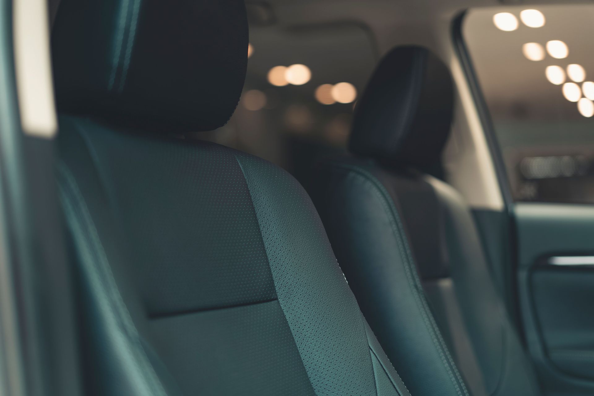Close-up of a luxury car's leather seats with a soft focus background, showcasing premium comfort